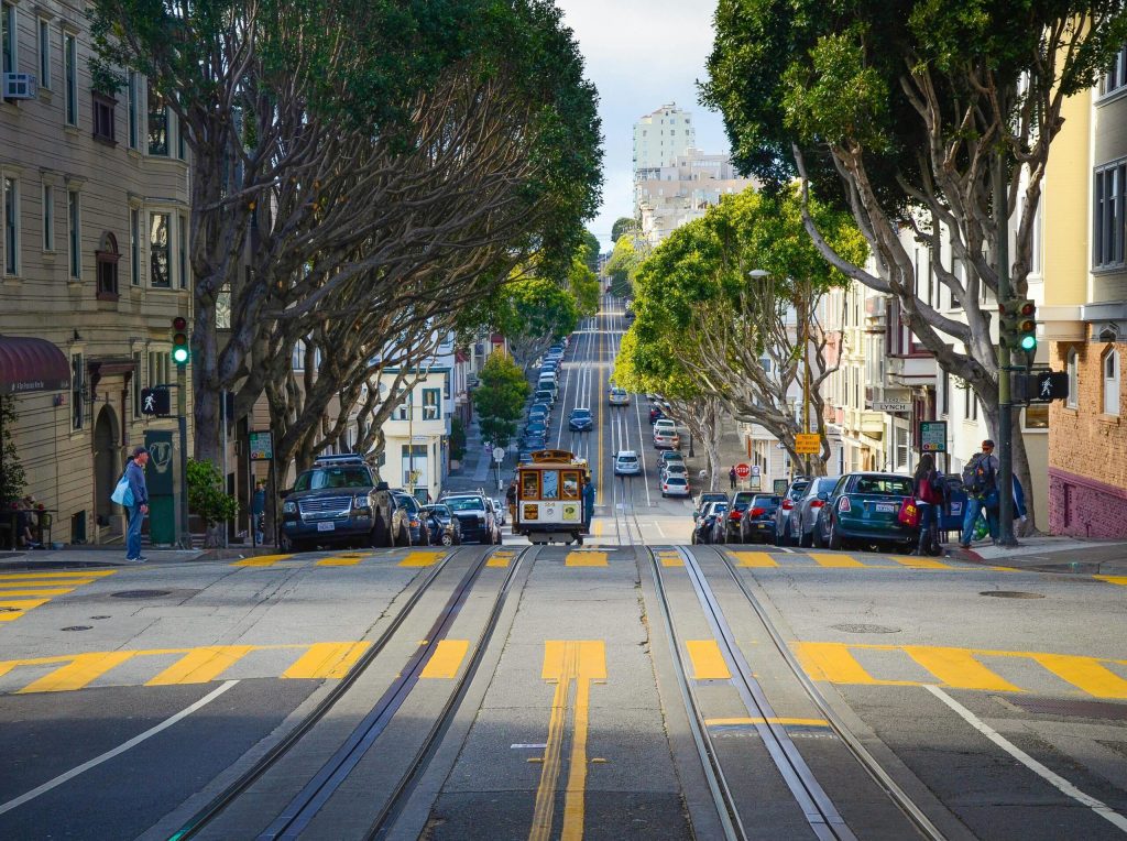 In the middle of a hilly San Francisco street with a tram on the tracks