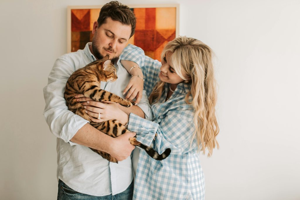 Couple holding on to their pet cat.