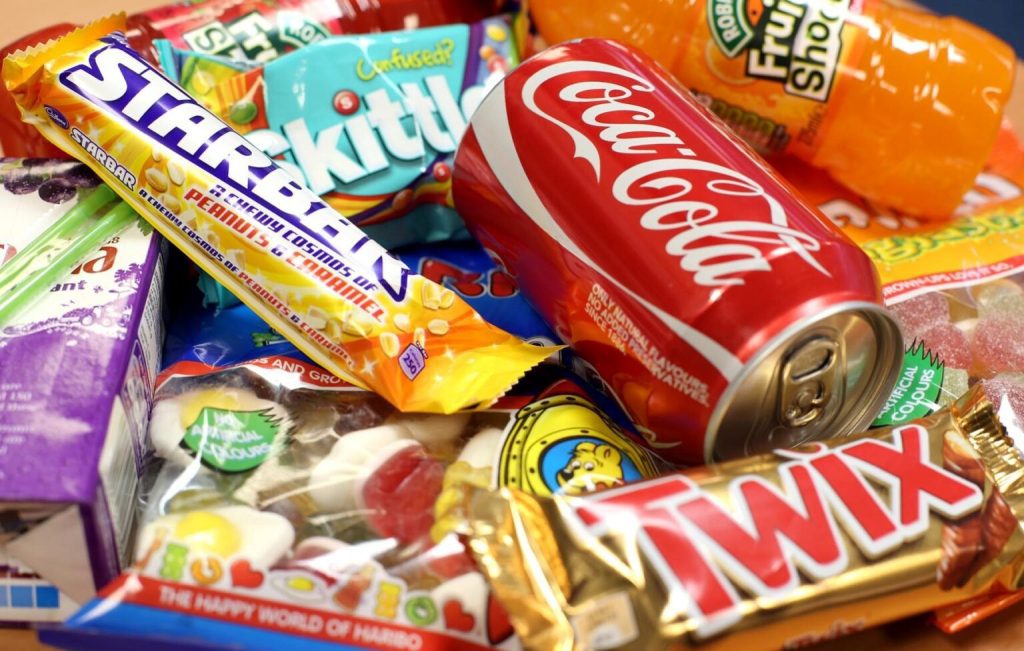 Pile of a variety of candy and sodas.