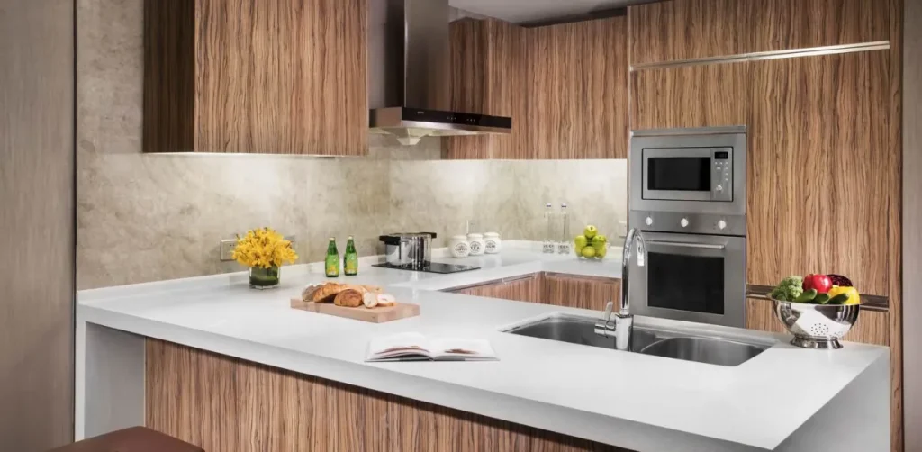 Modern appliance filled kitchen with granite countertops, wood cabinets.