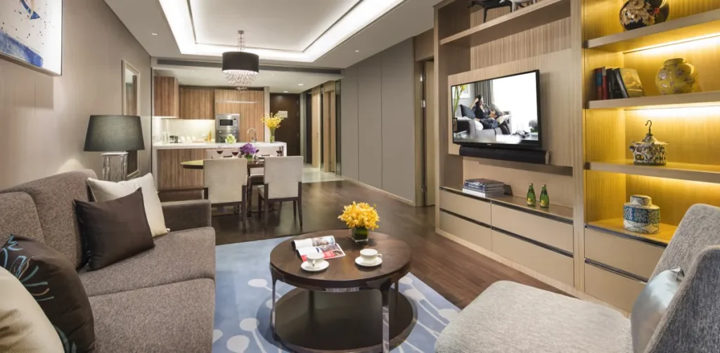 Contemporary living room space with wood finished floors, a smart tv, and wood finished shelving.