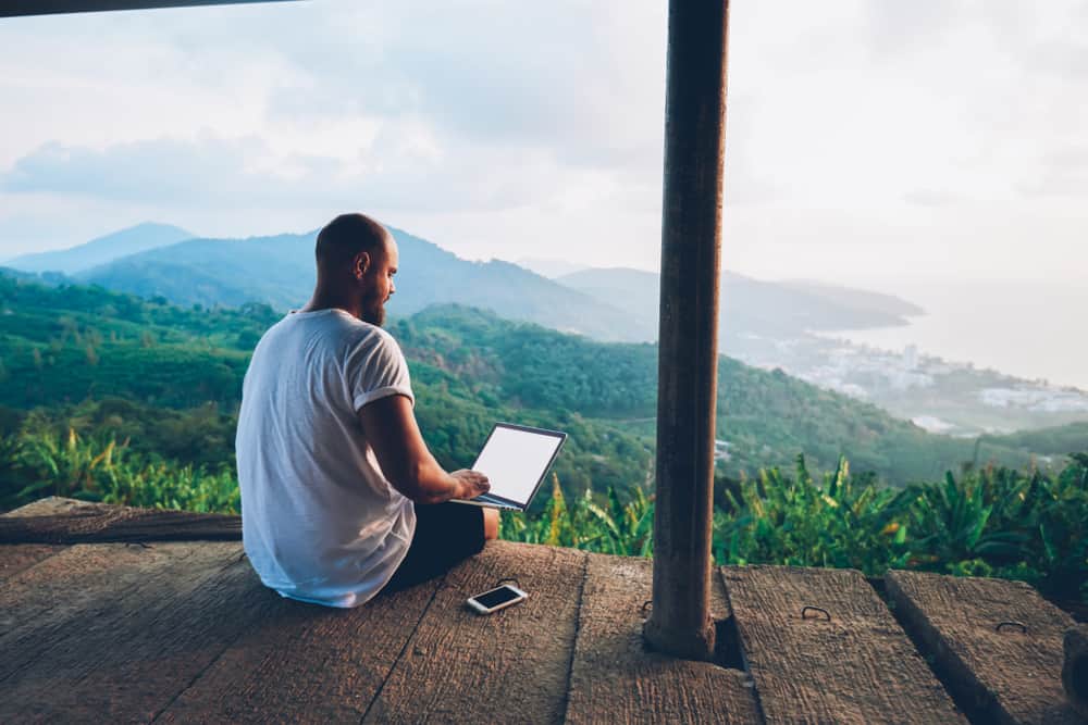 Man working on his computer from the mountains