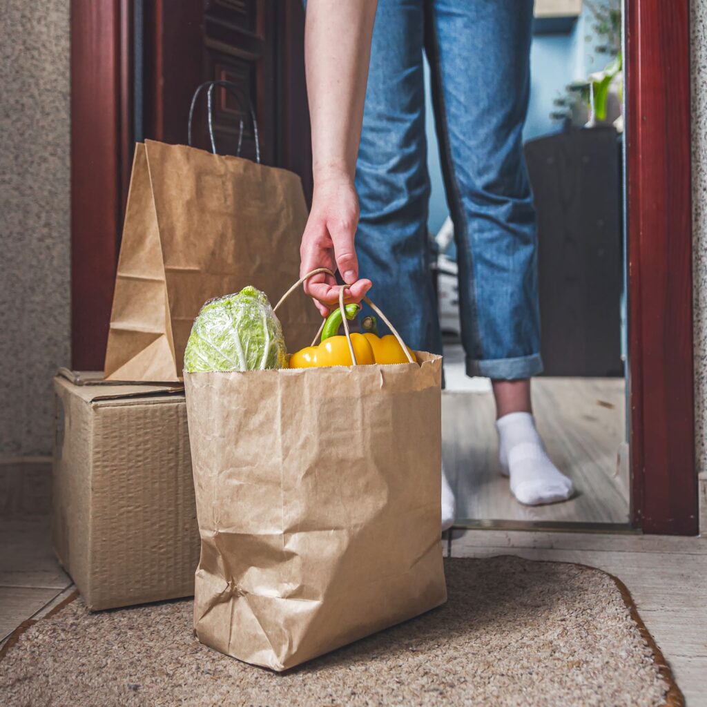 Person picking up groceries left on front door