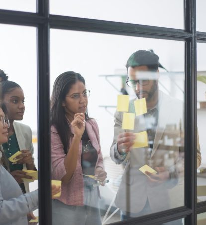 Co-workers organizing their thoughts with sticky notes.