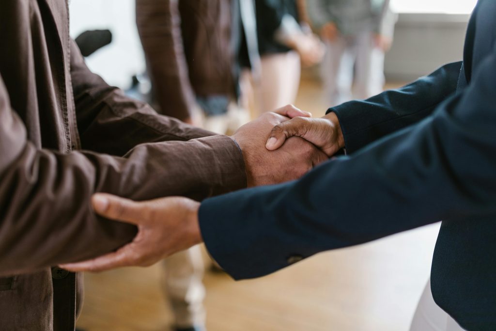 Two people come together for a handshake. 