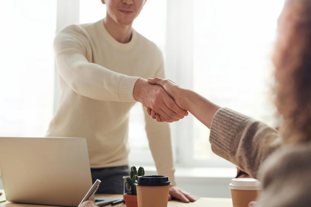 Man and Woman Near Table Handshake.