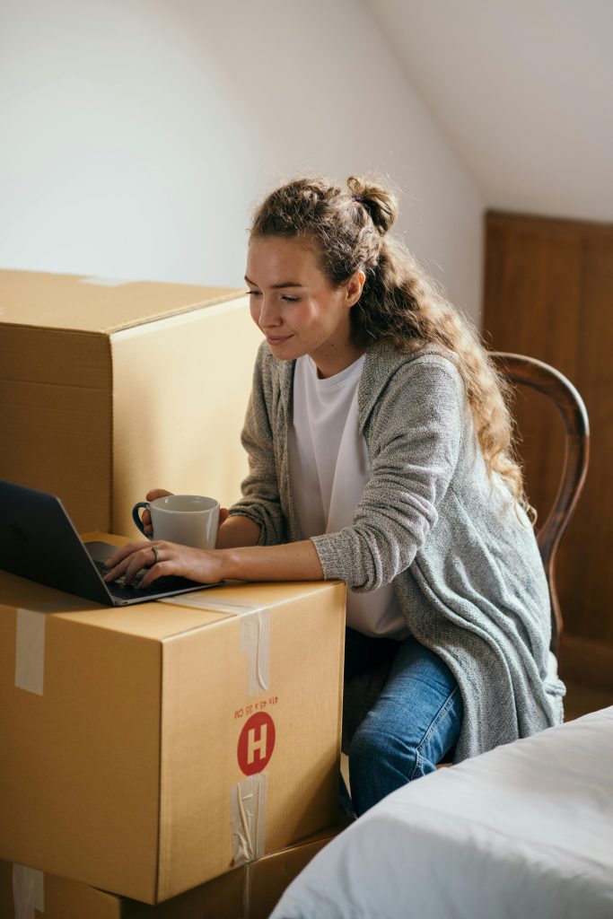 Woman working from her packed boxes.