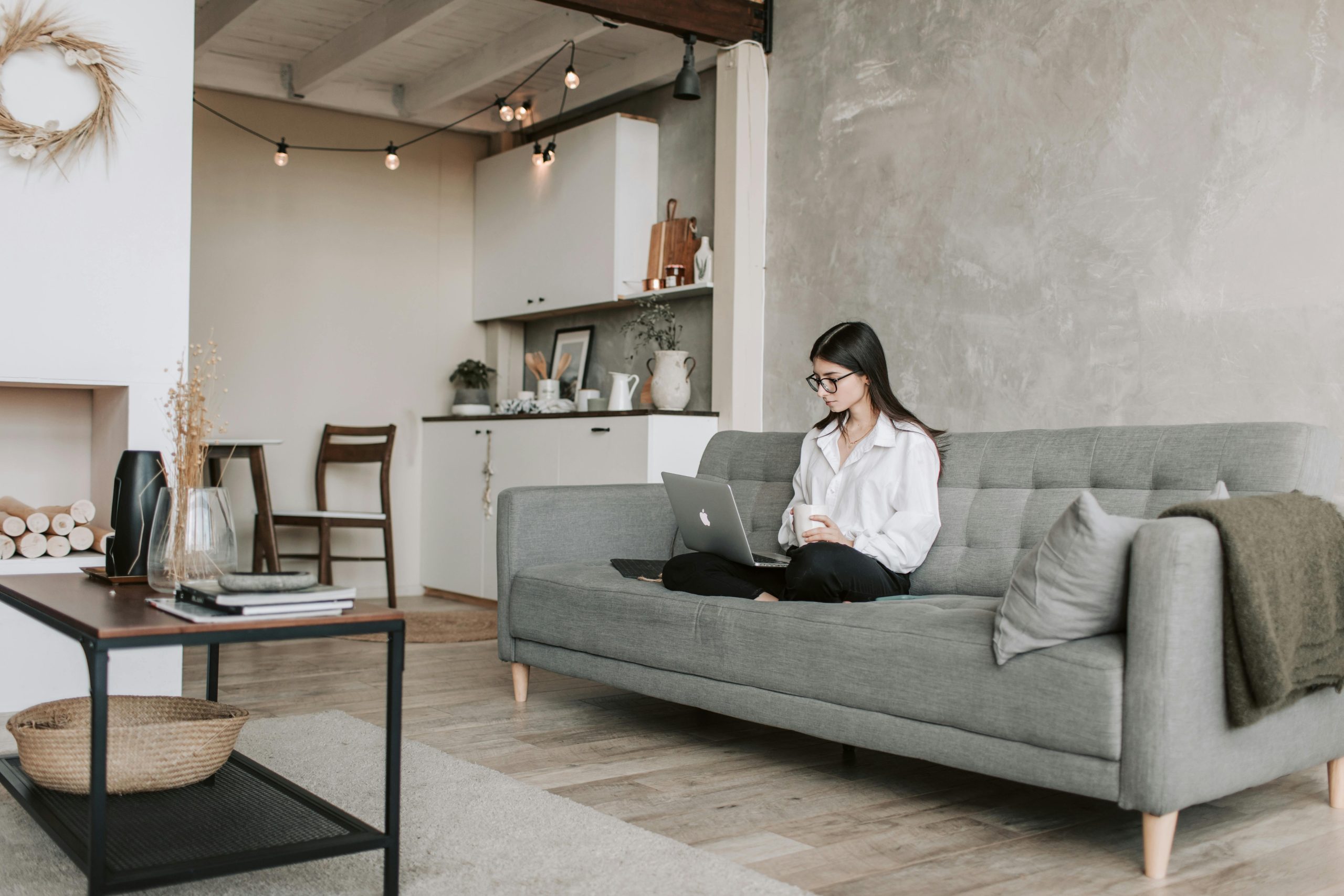 Woman sitting on her couch while working.