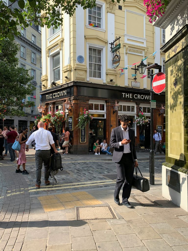 Business man walking through a busy London neighborhood.