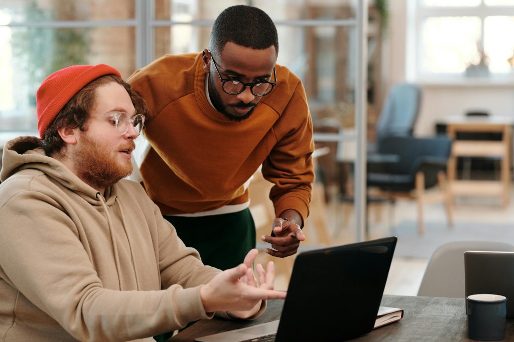 two men sitting at a computer